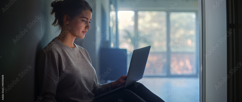 Young Woman Using Laptop at Home. Beautiful Girl Sitting on the Floor Uses Internet, Does Remote Wor