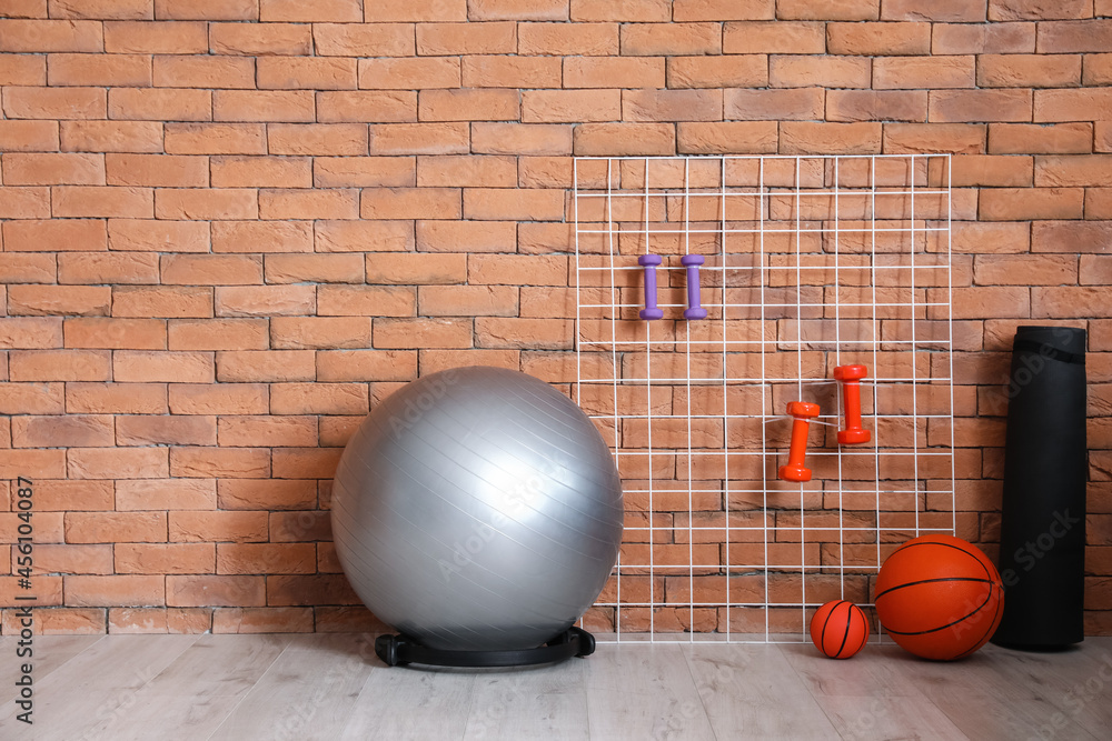 Different sports equipment  near brick wall