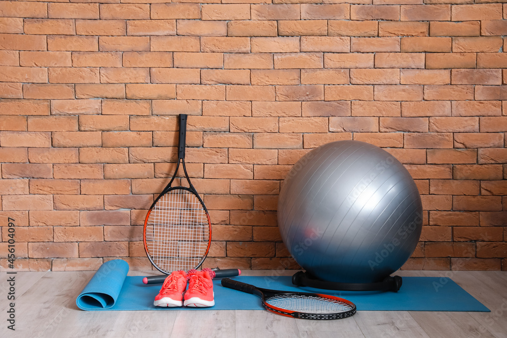 Different sports equipment  near brick wall