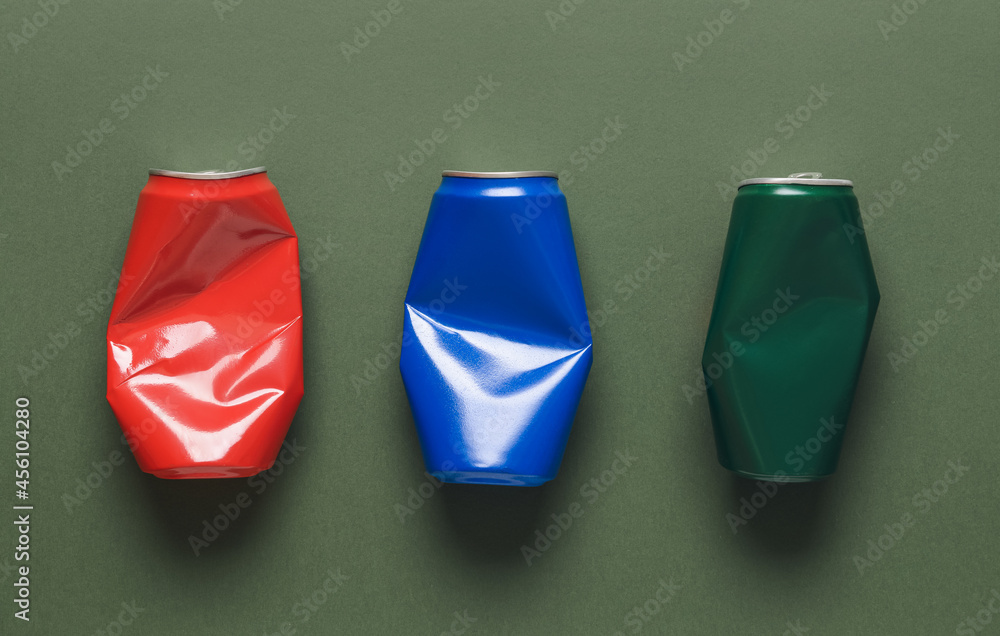 Crumpled cans of soda on color background