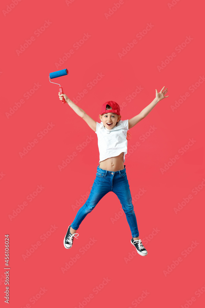 Little painter with roller jumping on color background