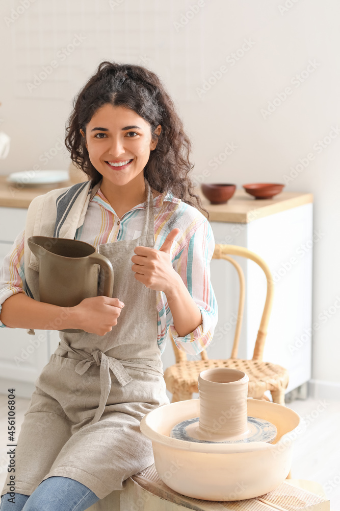 家里拿着陶瓷壶的年轻女子竖起大拇指