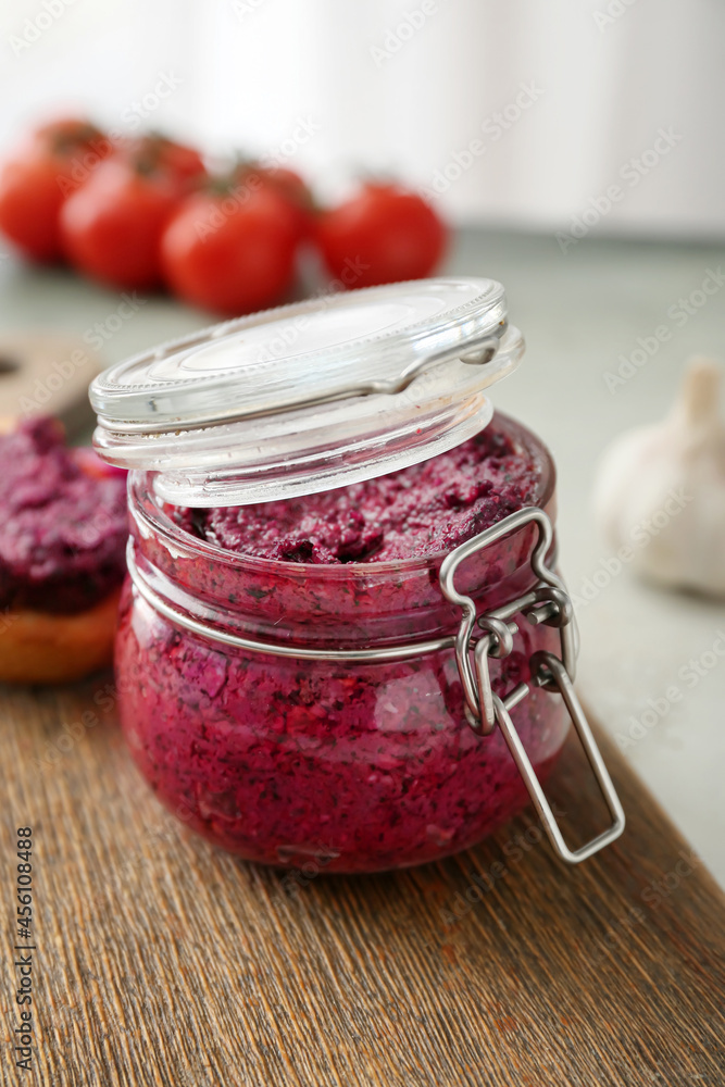 Jar of tasty pesto sauce on table