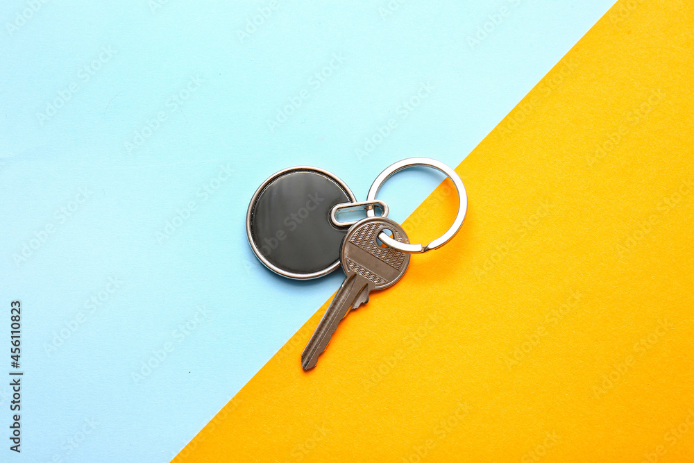 Key with stylish keychain on color background