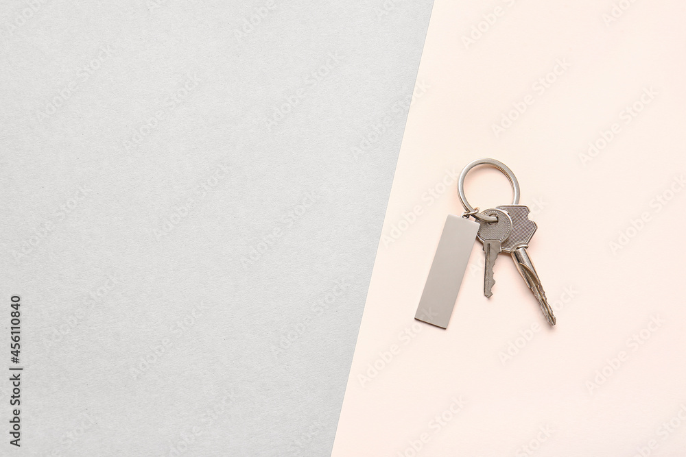 Keys with stylish keychain on color background