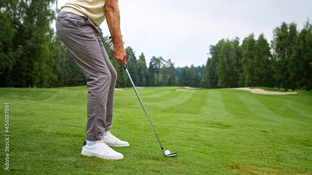 Young golfer in uniform making a hit with a club