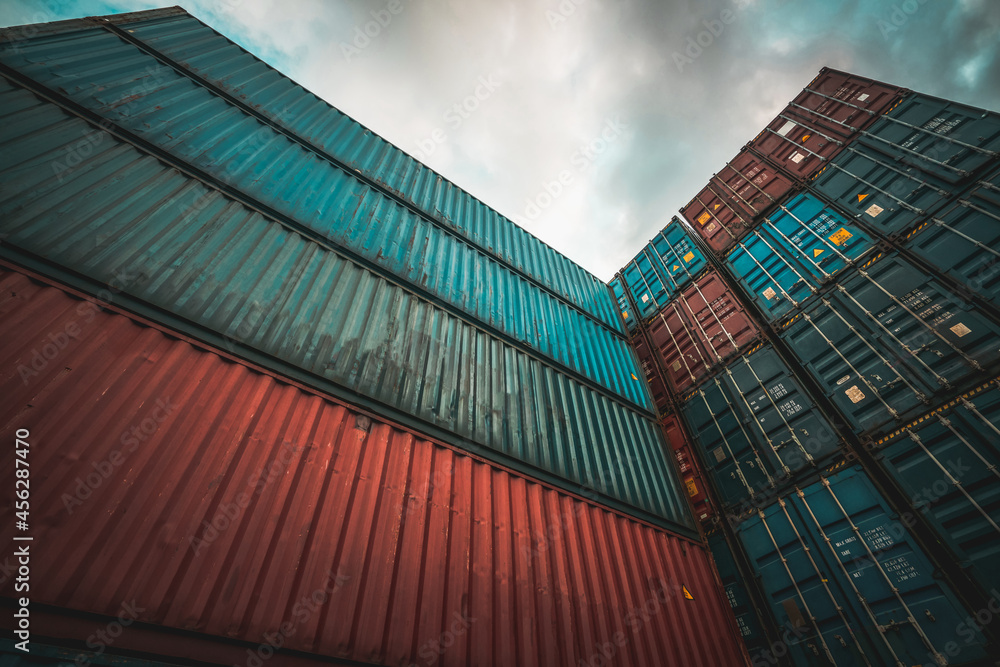 Cargo container for overseas shipping on high stack look up from ground . Logistics supply chain man