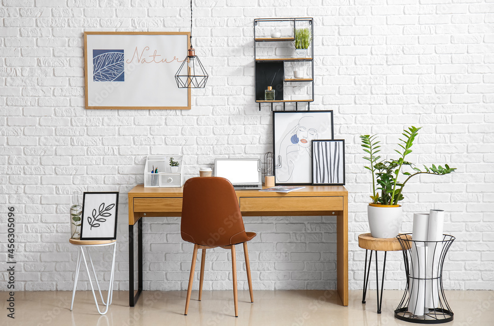 Interior of modern workplace near white brick wall