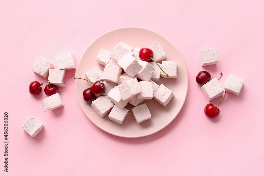 Plate with tasty sweet marshmallows and cherries on color background