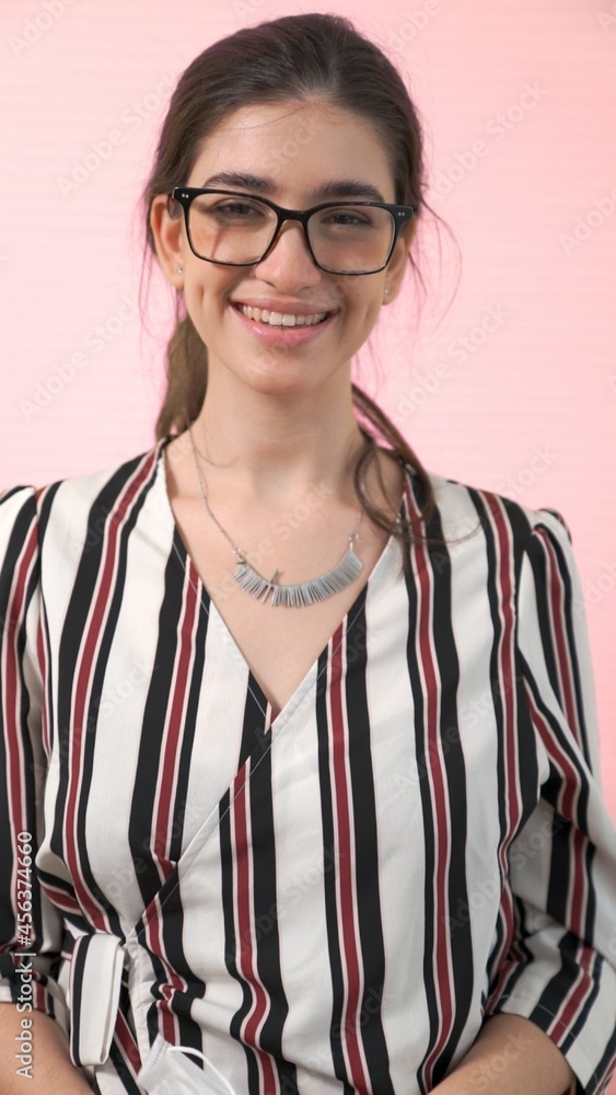 Portrait of young woman merrily pose in studio on clear background .