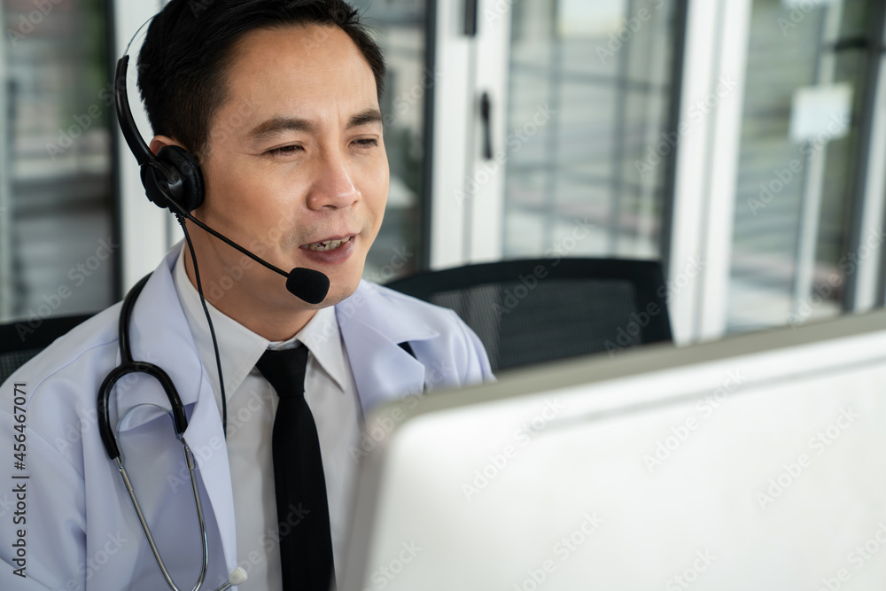 Doctor wearing headset talking actively on video call in a clinic or hospital . Concept of telehealt