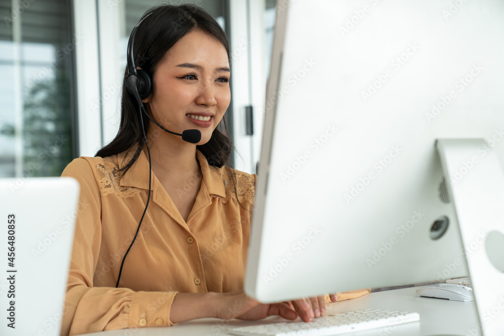 Businesswoman wearing headset working actively in office . Call center, telemarketing, customer supp