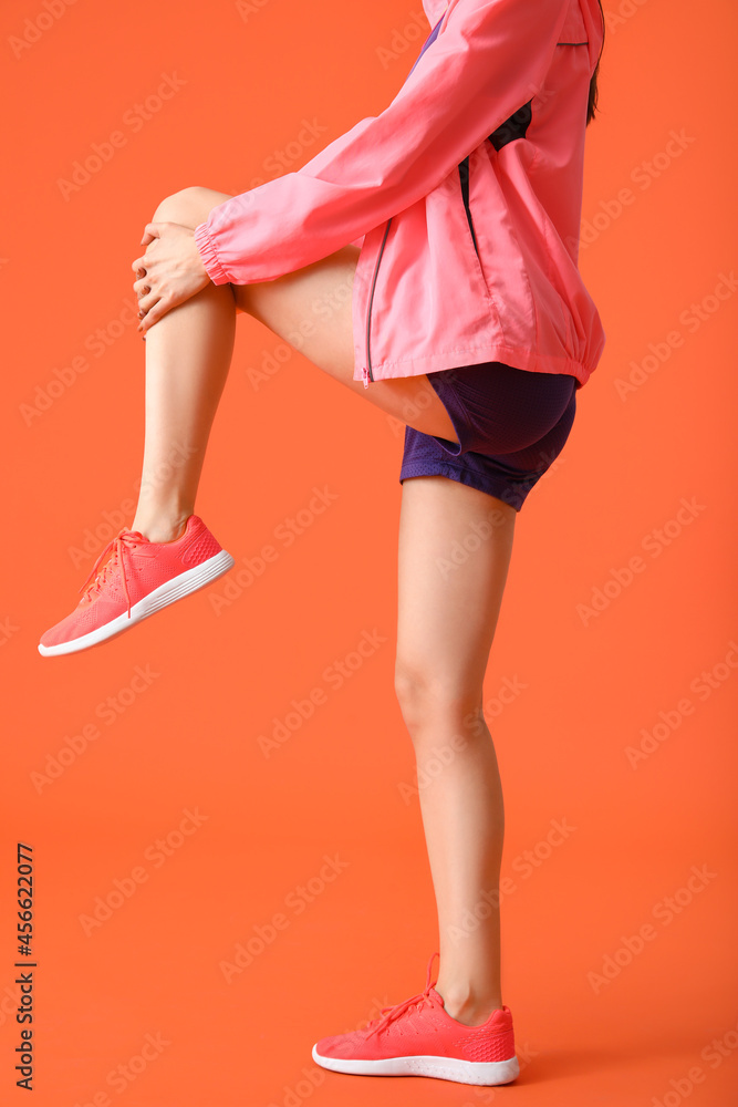 Sporty young woman on color background