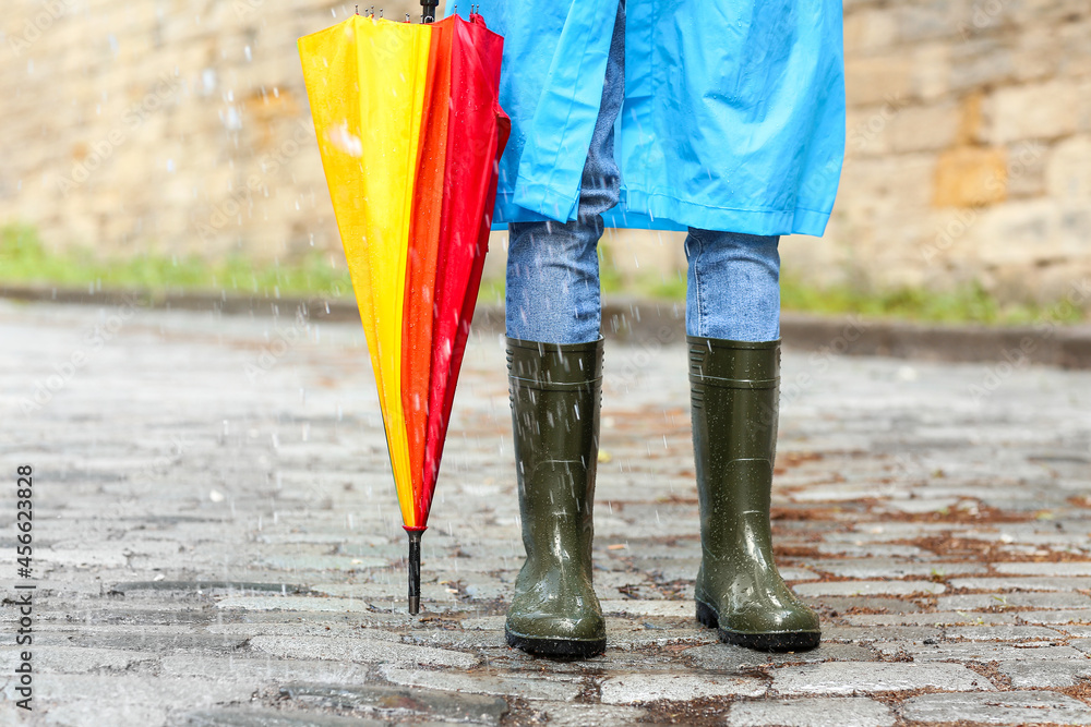 Young man with umbrella outdoors on rainy day