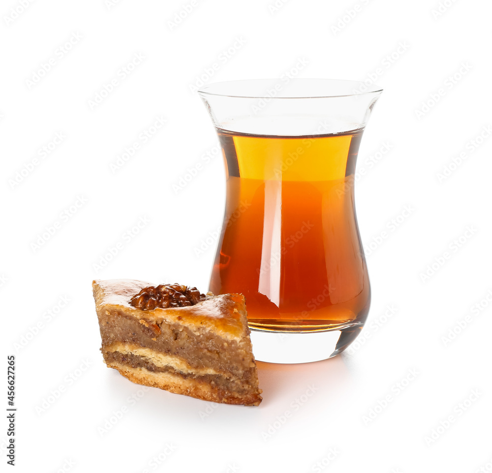 Tasty baklava and glass of Turkish tea on white background