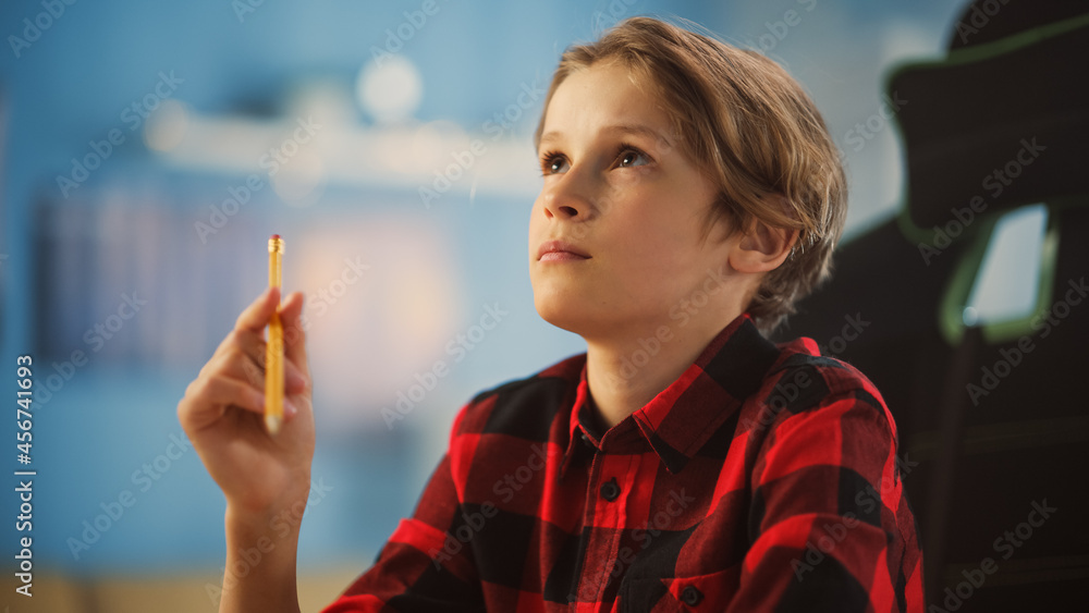 Portrait of a Bright Young Boy Being Concentrated, Looking into the Distance and Thinking About Some