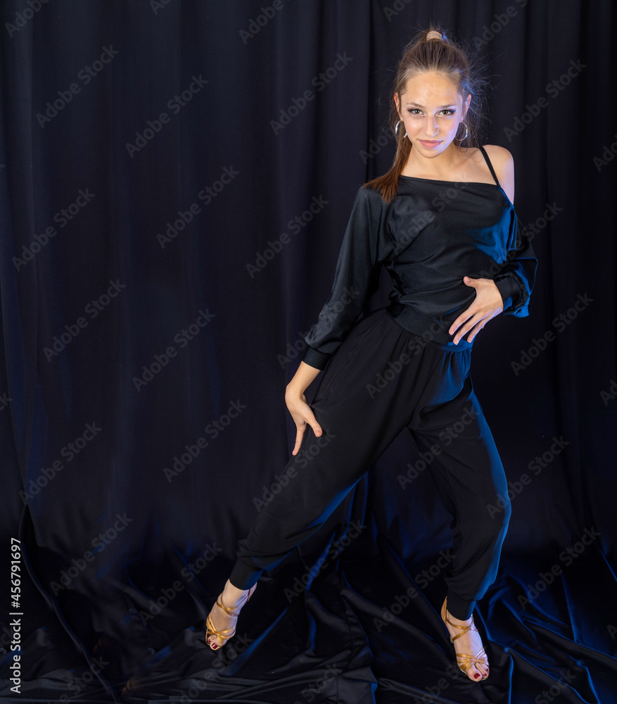 Attractive young girl dancing latino dance in studio