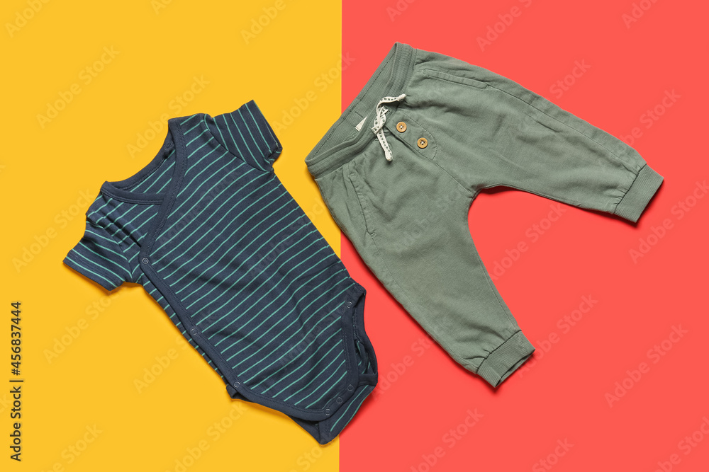 Stylish baby clothes on color background