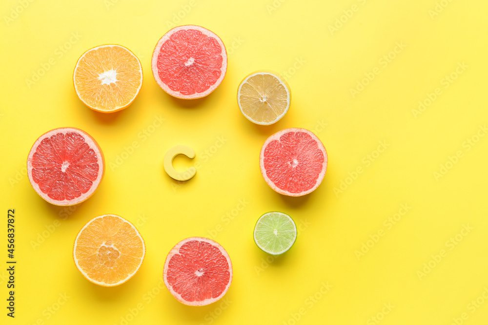 Letter C and cut citrus fruits on color background