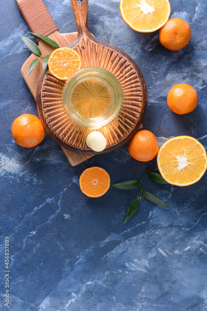 Glass with tasty drink, pills and citrus fruits on color background