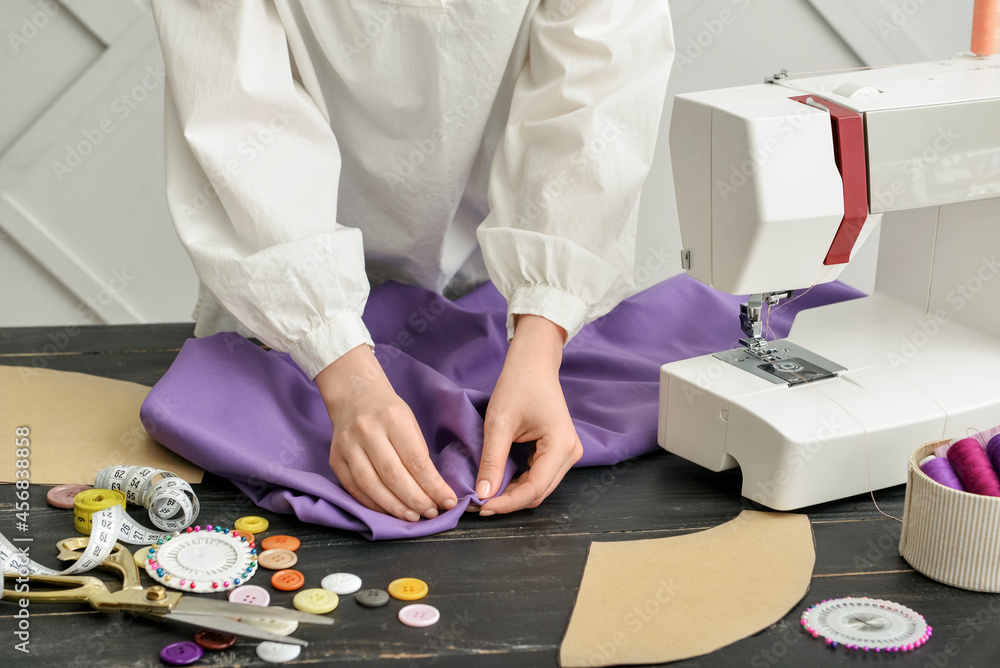 Woman sewing clothes on table