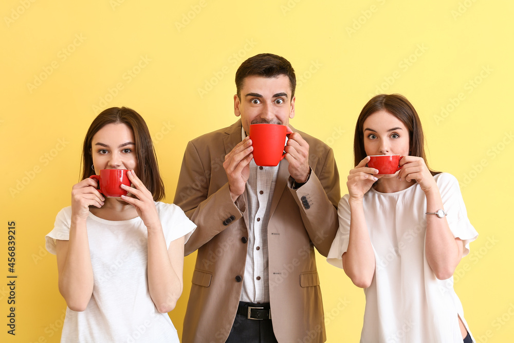 Business colleagues drinking coffee on color background