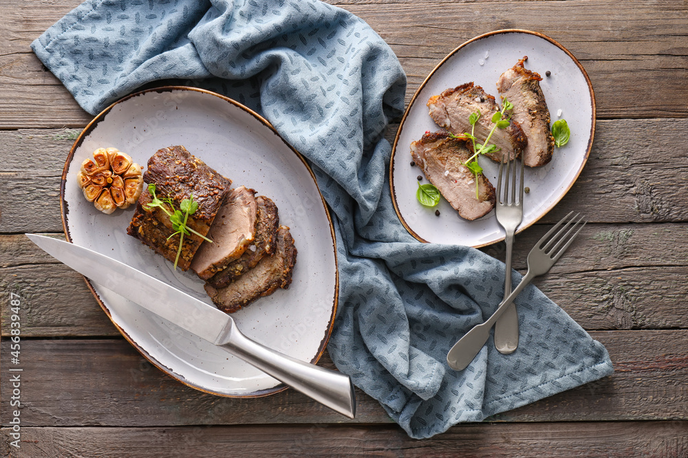 Plates with beef brisket on wooden background