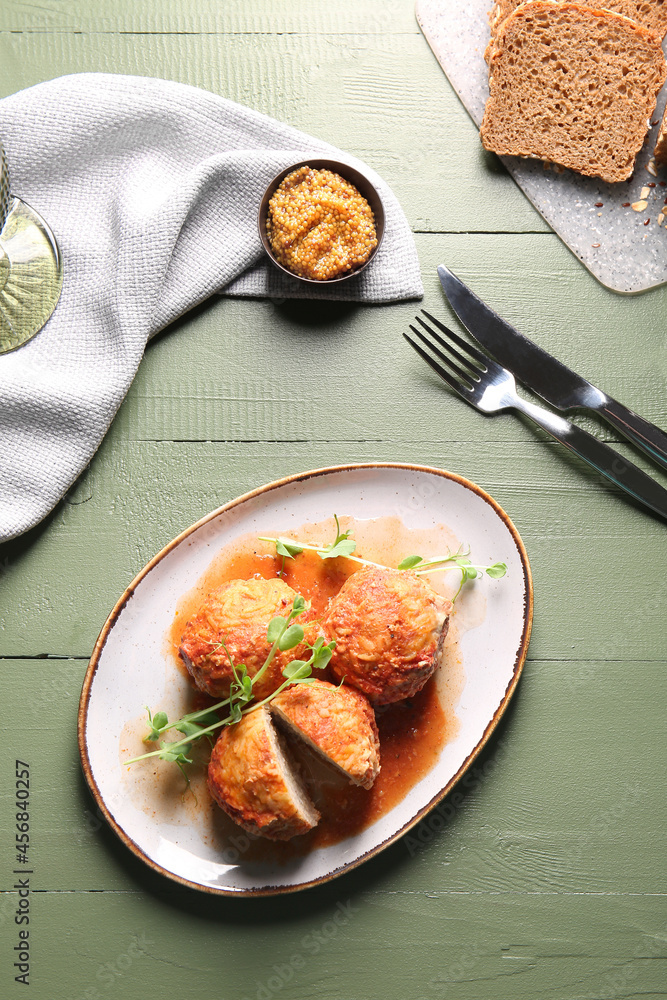 Plate with delicious meatballs on color wooden table