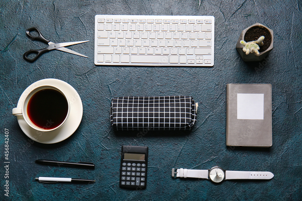 Composition with stylish pencil case, keyboard, cup of coffee and stationery on dark background