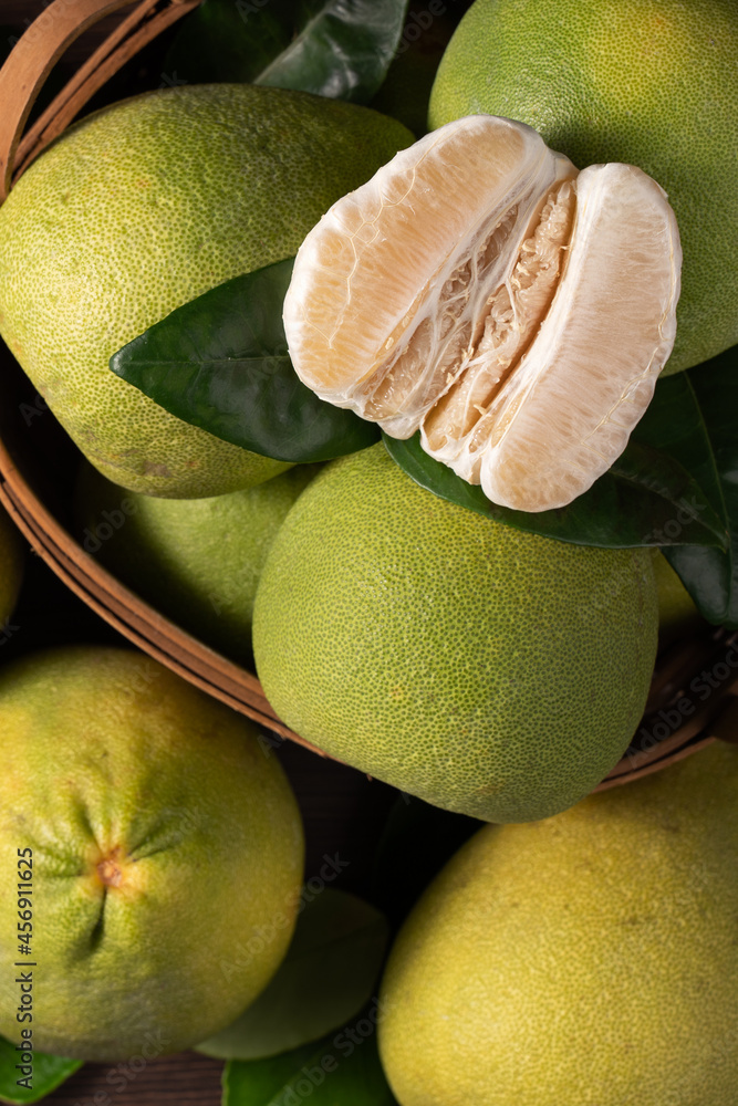 Fresh pomelo fruit on dark wooden table background.