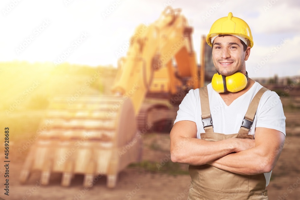 A young foreman looking into camera wearing a hard hat after a long day of work on site