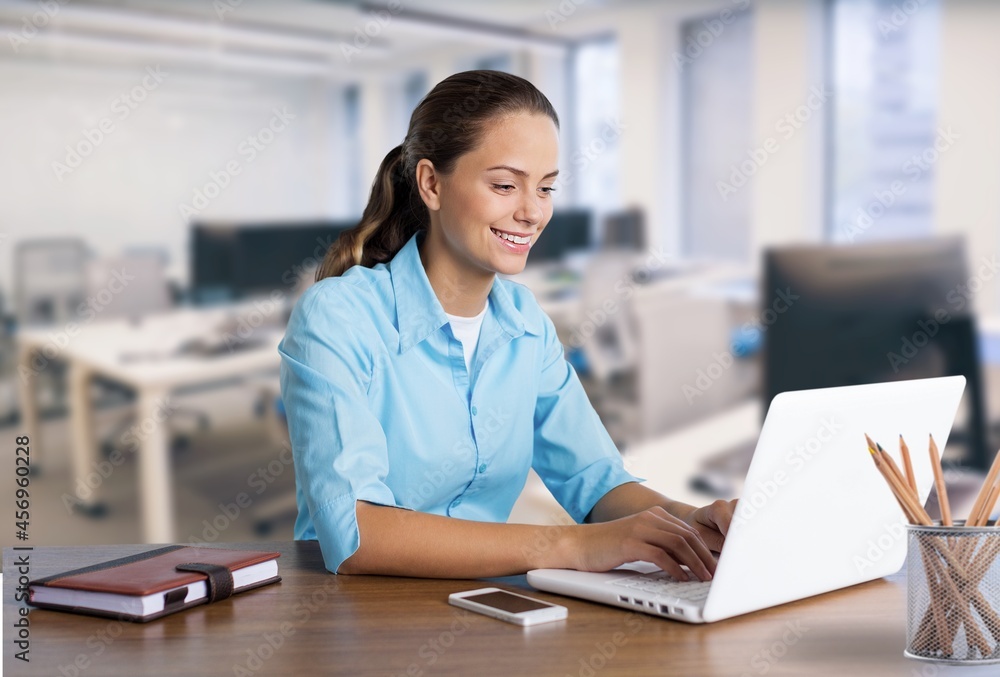 Beautiful businesswoman working with laptop computer at a desk in the office.