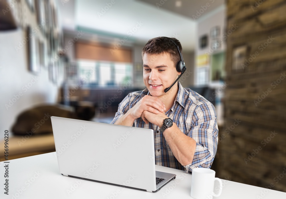 Happy man sitting on the couch with a laptop. Businessman making a video conference