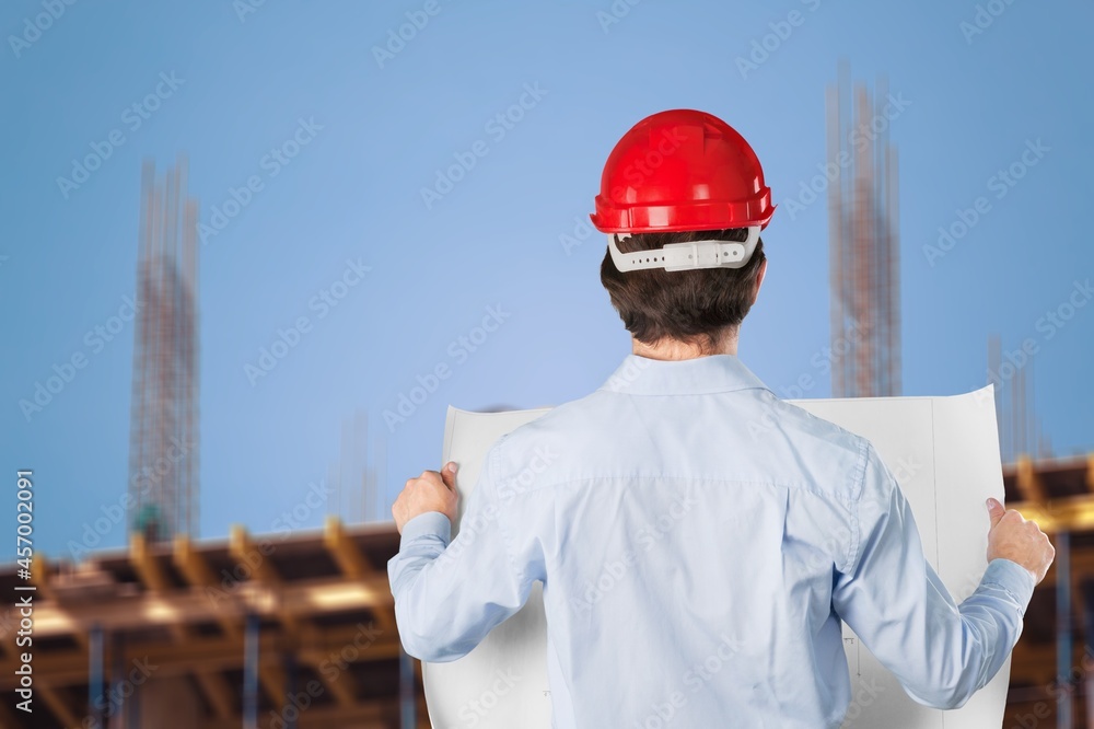 An electrician on the background of high towers of power plants looks at the project concept