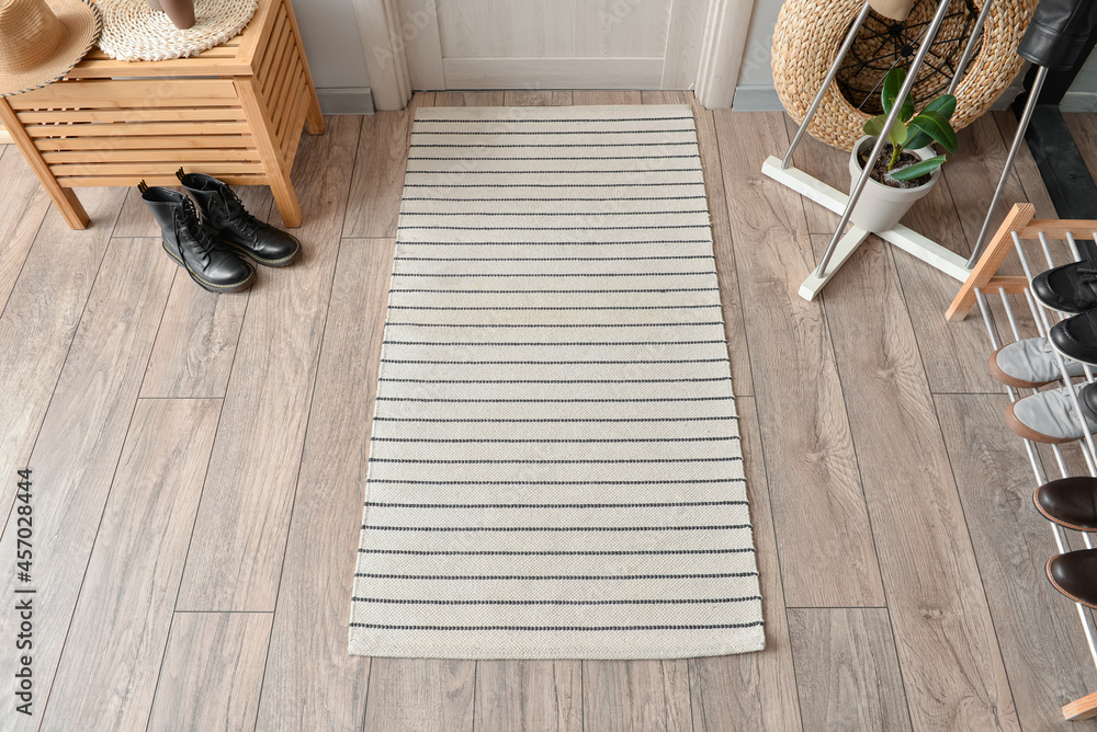 Stylish rug on floor in interior of modern hallway