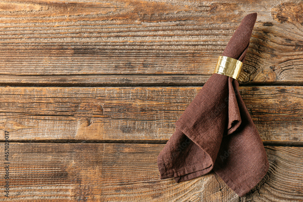 Stylish napkin with ring on wooden background