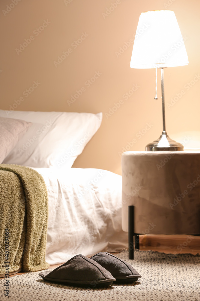 Male soft slippers on rug in bedroom