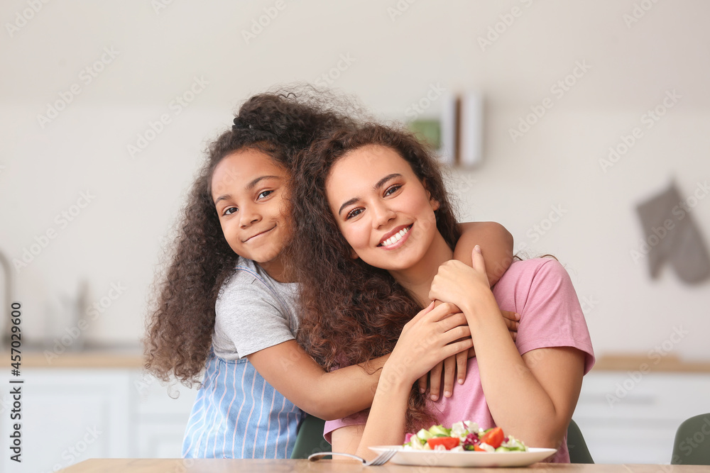 African-American little girl with her mother in kitchen