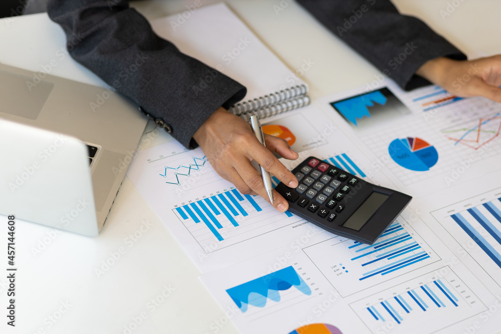 Close-up of business women using calculators to calculate business financial data analysis.