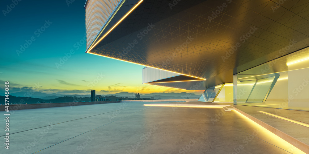 Perspective view of empty cement floor with steel and glass modern building exterior