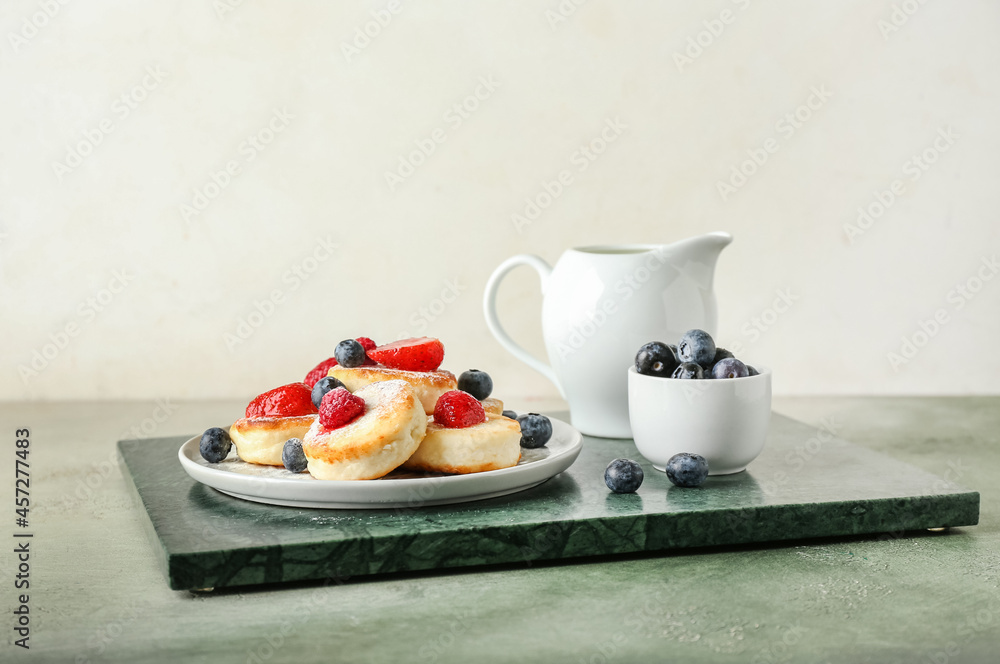 Plate with tasty cottage cheese pancakes and berries on table