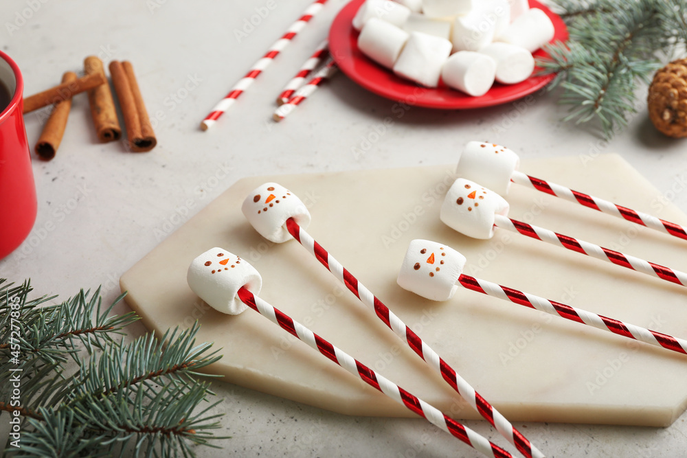 Snowmen made of soft marshmallows on light background