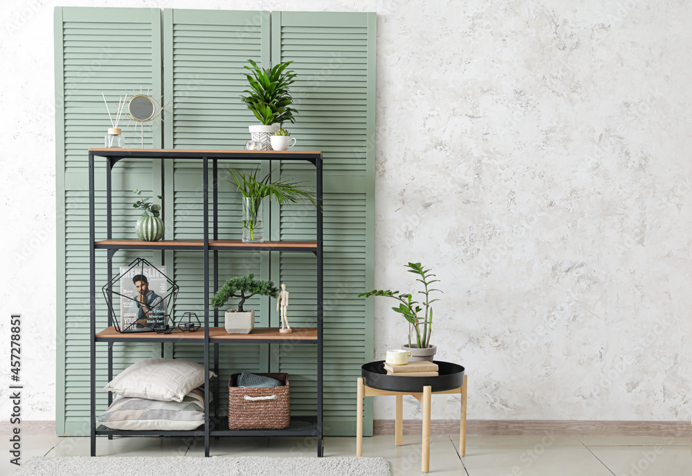 Interior of modern room with stylish shelves and folding screen