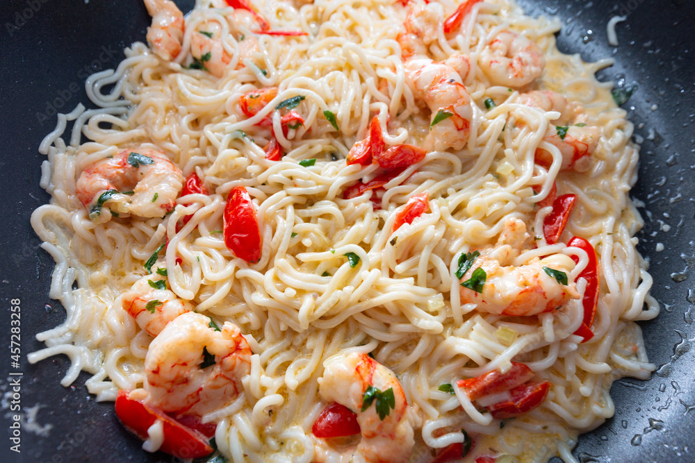 Noodles with prawns in cream sauce with cherry tomatoes