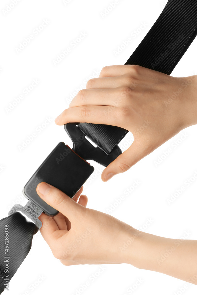 Woman fastening seat belt on white background