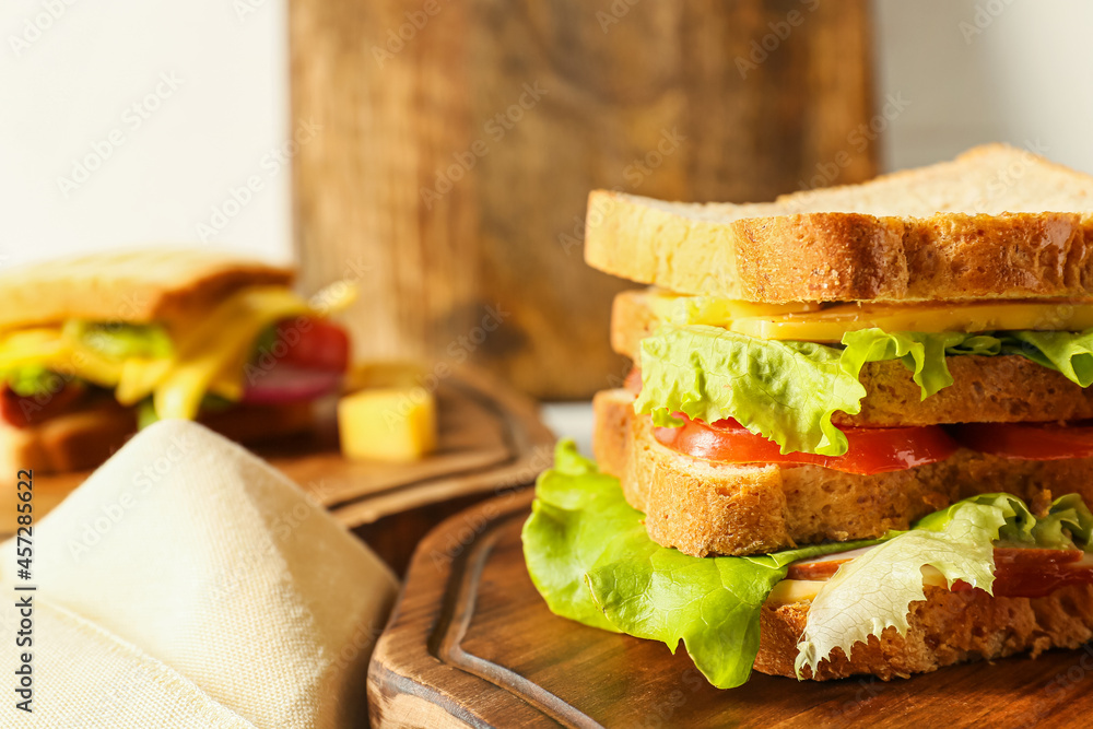 Board with tasty sandwich on table, closeup