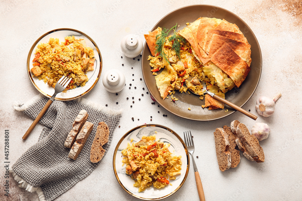 Plates with tasty Shah Pilaf on light background