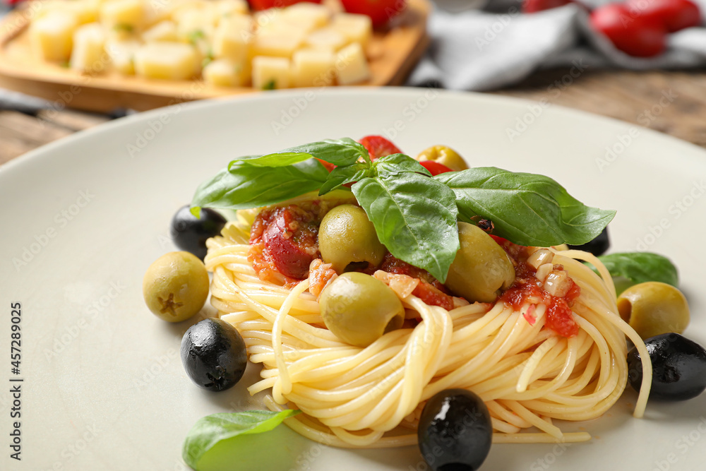 Plate with tasty Pasta Puttanesca on table, closeup