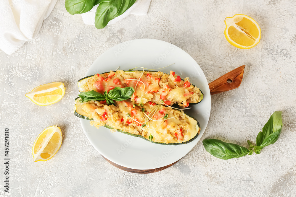 Plate with quinoa stuffed zucchini boats on light background