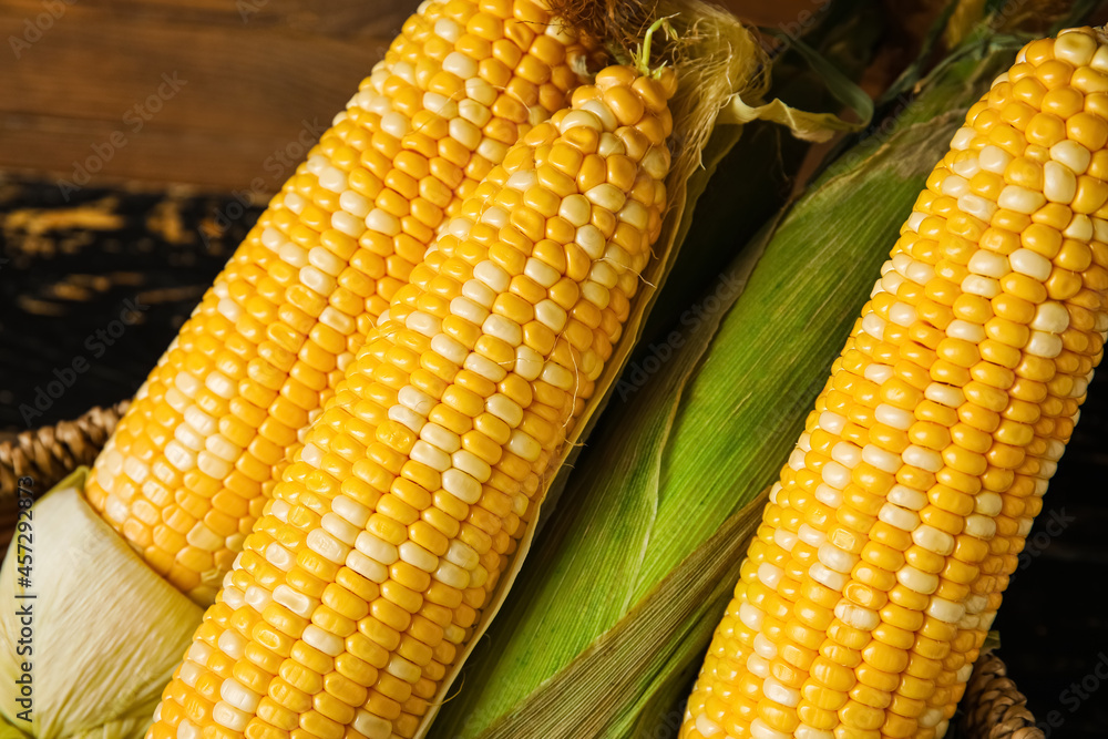 Wicker basket with fresh corn cobs, closeup